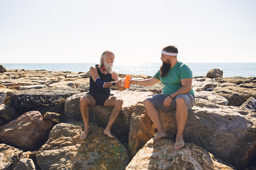 Morning fitness session with bearded father and son on the beach, near Borriana, Spain.