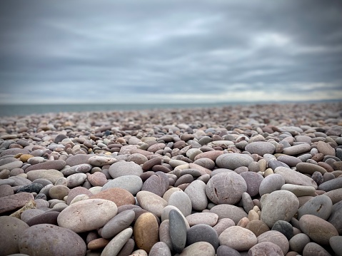 Pebble beach devon, sea, cloudy sky. Stones, rounded.