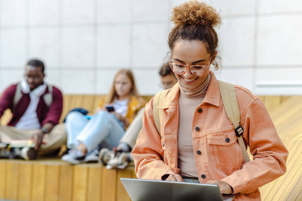 istock Young female student using laptop on the bench on campus 1482680500