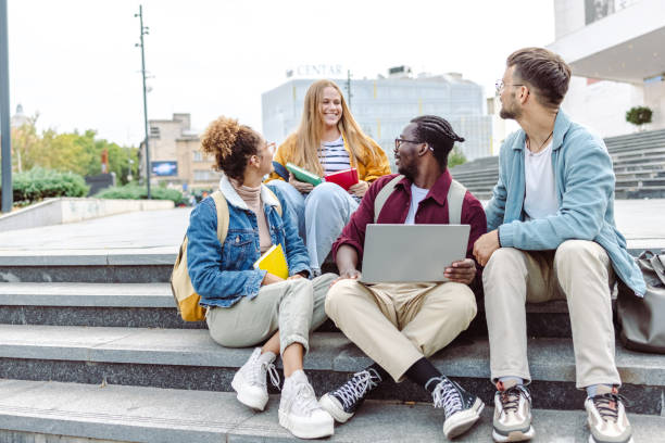 istock Hanging out on campus. Young group of students using laptop 1482680811