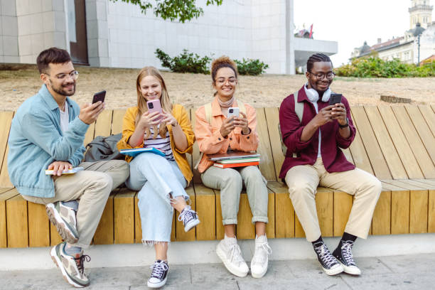 istock Group of cheerful students sitting together and using their smart phones 1482681210