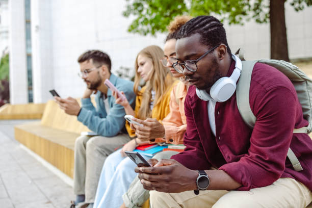 istock Group of students sitting together and using their smart phones 1482681221