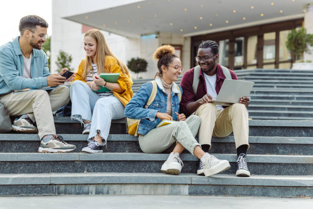 istock Hanging out on campus. Young group of students using laptop 1482681447