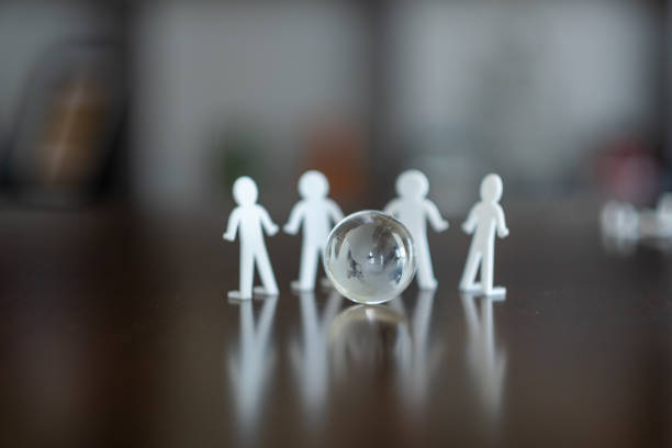 Human figures stand around the glass globe