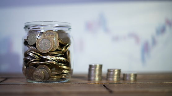 Coin saving jar and finance chart concept photo