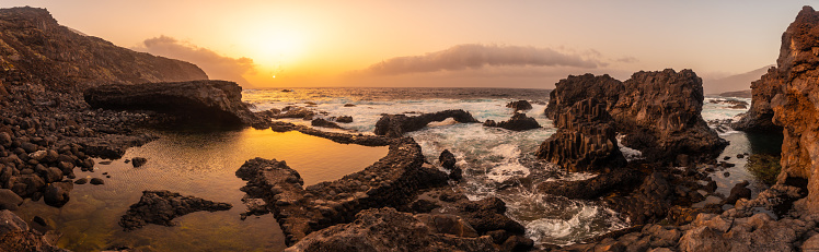 El Hierro Island. Canary Islands, panoramic landscape of volcanic rocks in Charco Azul natural pool in spring orange sunset