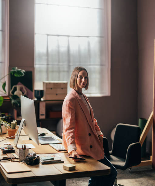 A Happy Beautiful Blonde Businesswoman Looking At Camera While Working In Her Office