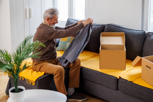istock A senior man is prepping a donation box with clothes. 1482693977