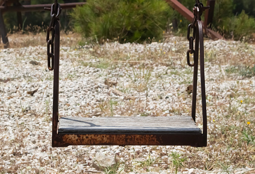 swing made of iron and wood in an abandoned playground. swing ruins.