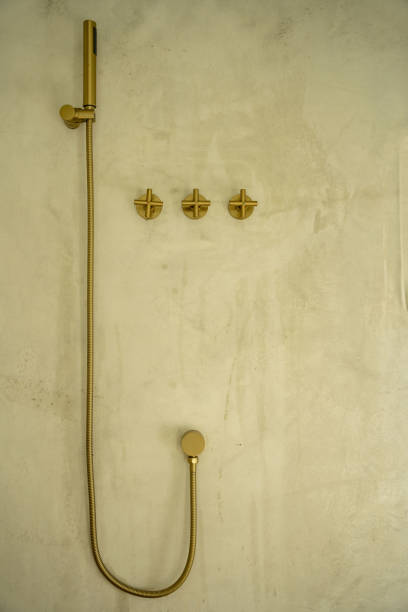 istock Luxury brass shower with hand held faucet on a stone wall. 1482698050