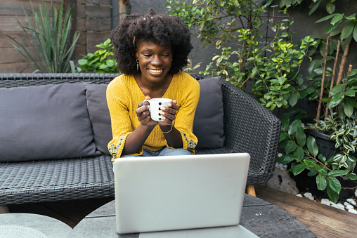 istock Portrait of a happy African American businesswoman working online at her garden 1482703178