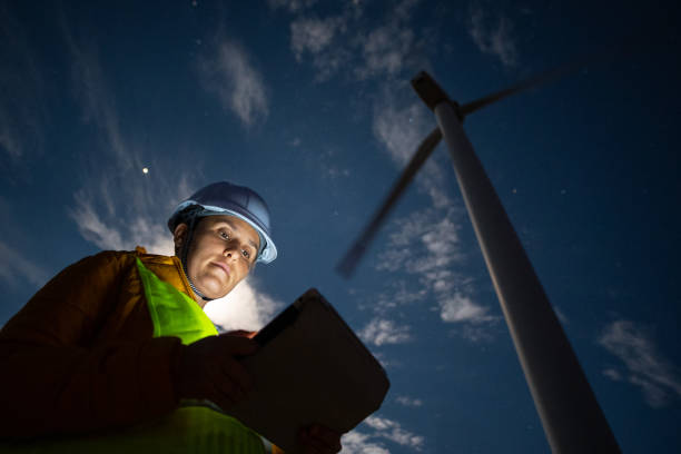 istock Pregnant wind energy engineer working late at wind farm. 1482703434