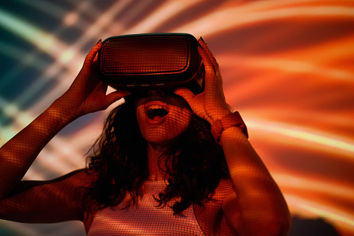 VR. Long-haired woman in vr viewer on abstract bright background