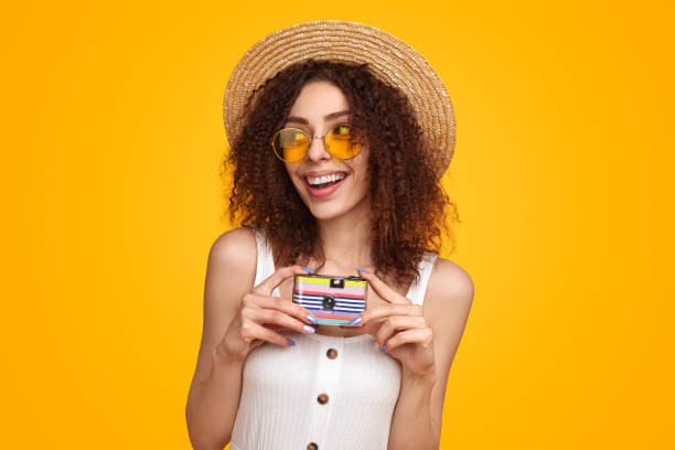 Traveling woman with retro camera in studio