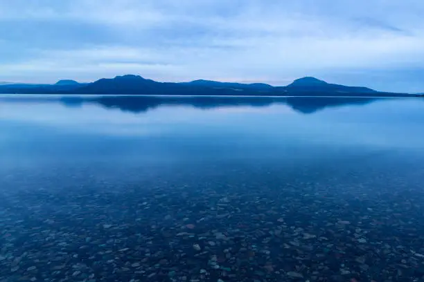 A bluish view of the lake under cloudy skies. Lake Kussharo in Hokkaido.