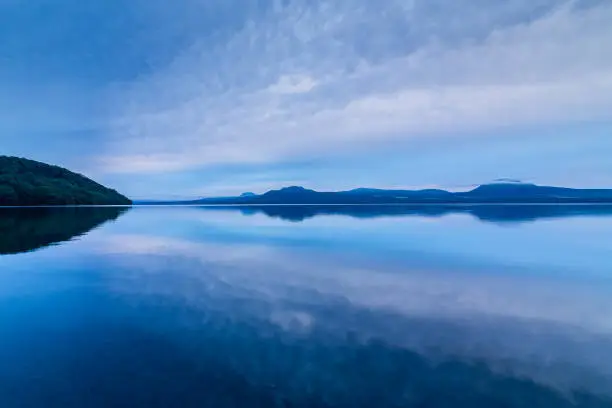 A bluish view of the lake under cloudy skies. Lake Kussharo in Hokkaido.