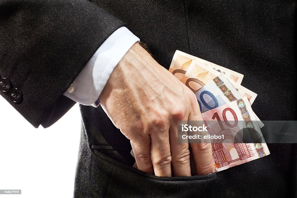 Businessman putting money in his pocket. Businessman putting money (euro banknotes) in his pocket. Adult Stock Photo