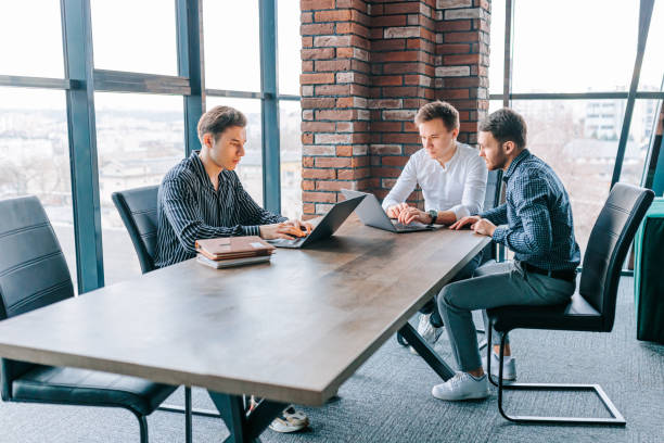 istock A group of guys collaborating on their laptops, with their trainer providing guidance 1482714264