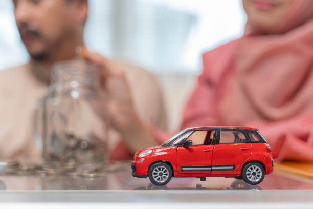 femme mettant de l’argent dans le bocal en verre étiqueté tenu par un homme, économiser et investir de l’argent pour préparer à l’avenir. concept d’économie d’argent pour acheter une voiture - asian tribal culture photos photos et images de collection