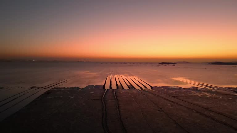 Tidal flats before dawn and fishing boats moored at sea