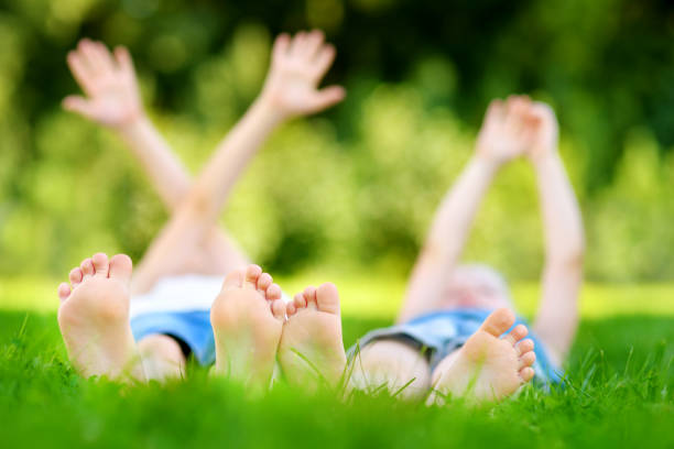 istock Two children's feet on grass outdoors in a park 1482722104