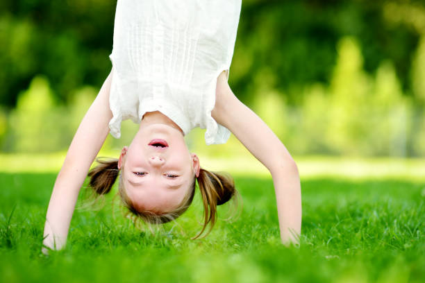 istock Happy young child playing head over heels on green grass 1482722165