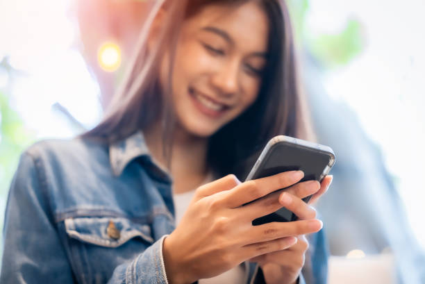 istock Young asian beautiful woman using smart phone in coffee shop cafe, typing write message on mobile, online shopping, transfer payment, internet banking 1482725231