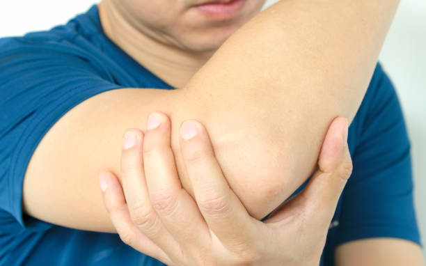 man touching the elbow with elbow pain And he relieves pain with massage. Health and healing concept. man touching the elbow with elbow pain And he relieves pain with massage. Health and healing concept. relieves stock pictures, royalty-free photos & images