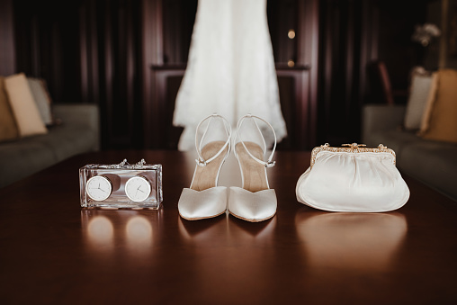 Wedding dress, shoes, purse and earrings laid out