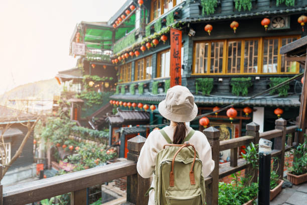 woman traveler visiting in Taiwan, Tourist with hat and backpack sightseeing in Jiufen Old Street village with Tea House background. landmark and popular attractions near Taipei city. Travel concept woman traveler visiting in Taiwan, Tourist with hat and backpack sightseeing in Jiufen Old Street village with Tea House background. landmark and popular attractions near Taipei city. Travel concept taipei stock pictures, royalty-free photos & images