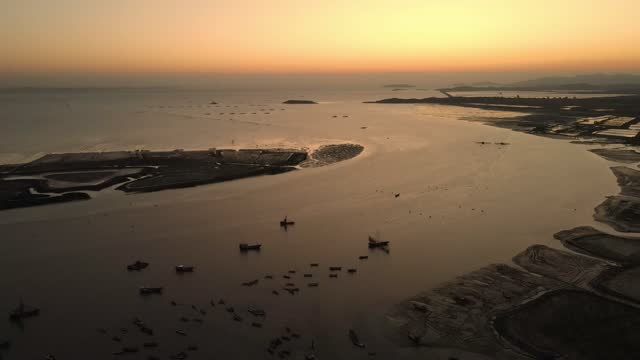 Aerial view of tidal flats by the sea with moored fishing boats
