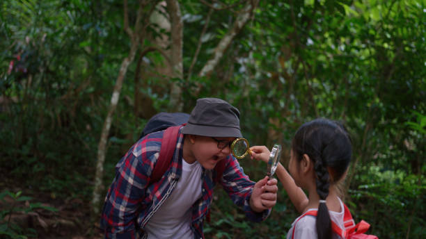 istock Children playing with a magnifying glass in the forest 1482730127