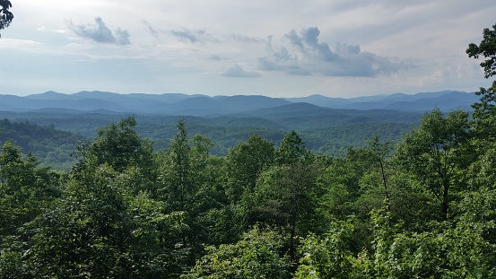 This is a scenic view of Green treetops and the Blue Ridge Mountains on an overcast summer day in Helen, Georgia in Southern USA.