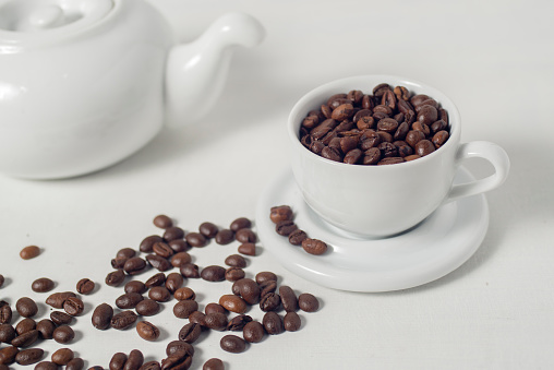 Roasted coffee bean in a cup isolated white background