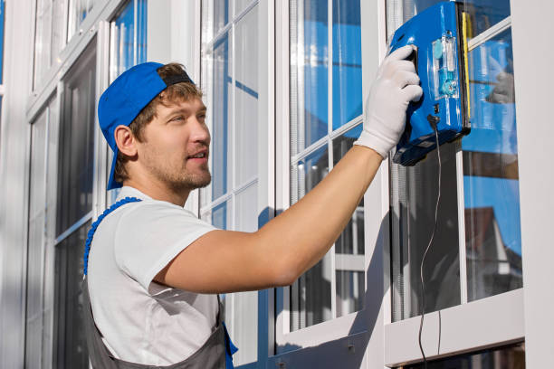 istock worker in overalls, cap and gloves adjusts square robot for washing windows 1482735081
