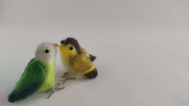 A plush toy of a small bird made from wool felt