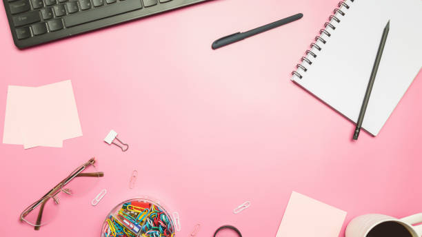 istock Modern workspace with coffee cup, keyboard and notebook on pink background. Top view. Flat lay 1482742968