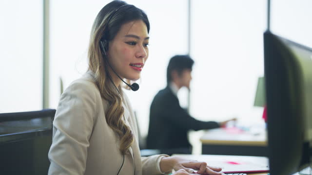 Business employee in office working at table on call service center to support customer online