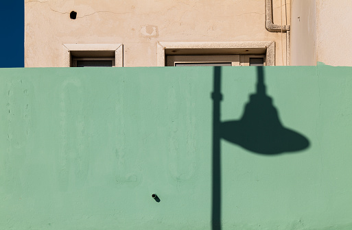 Shadow of street lamp on green wall. Almeria, Spain