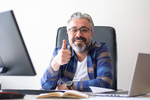 istock Stylish casual handsome man working with computer in his office. surfing the internet. Looking at economic data 1482753732