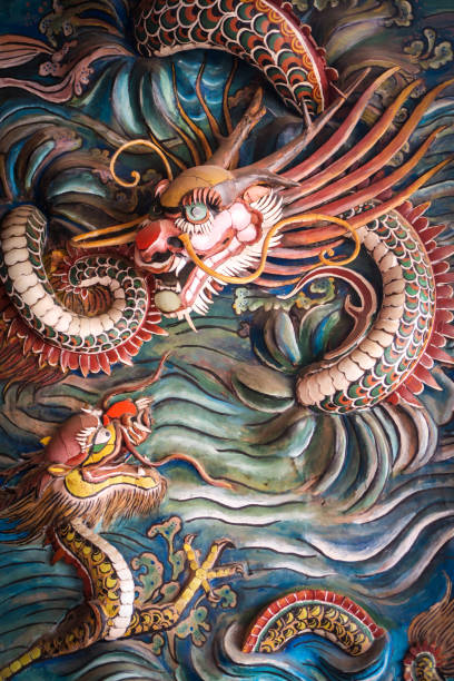 Twisted Chinese dragons in Malacca Chinatown Ancient wooden relief of flying angry looking Chinese dragons painted in motley colors titled "Dragons In The Sea" on wall of 17th century Cheng Hoon Teng Temple in Chinatown of Malacca City, Malaysia. The UNESCO heritage site is publicly accessible dragon in chinese temple stock pictures, royalty-free photos & images