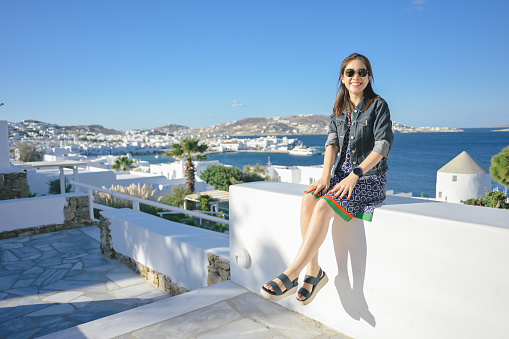 Asian tourist travel waiting for passenger ship greece mykonos Santorini greece