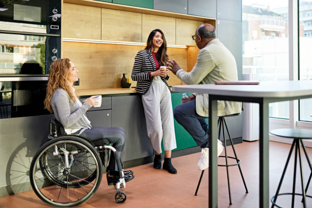 istock Coworkers relaxing in office kitchen and talking 1482758033