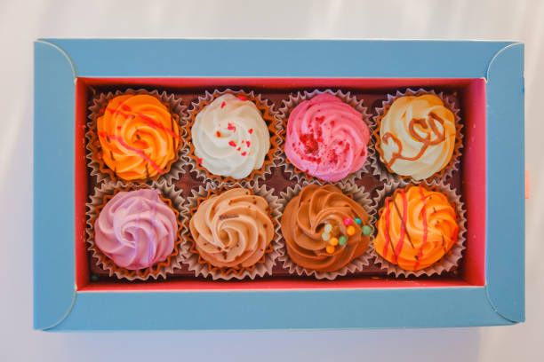 istock Assorted sweet pastries.cupcakes with cream set in a box on a white background. Appetizing cupcakes and pastries.Choux pastry. Baked goods and desserts. 1482758108