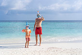 Dad teaches son to snorkel in the Maldives