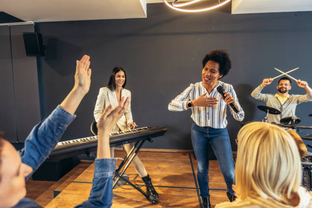 istock Business people making team training exercise during team building seminar singing karaoke. 1482759548