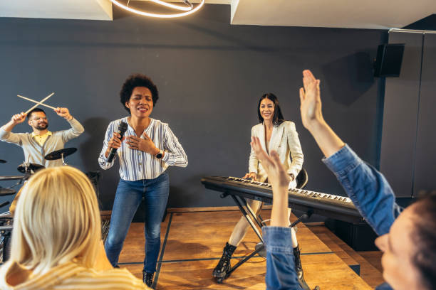 istock Business people making team training exercise during team building seminar singing karaoke. 1482759549