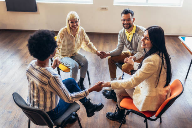 istock Group of people sitting in a circle are participating in a support meeting. 1482759590