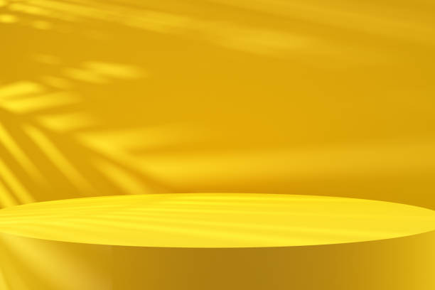 istock Close up round yellow colored podium with tree leaf shadows and natural sunlight. 1482760793