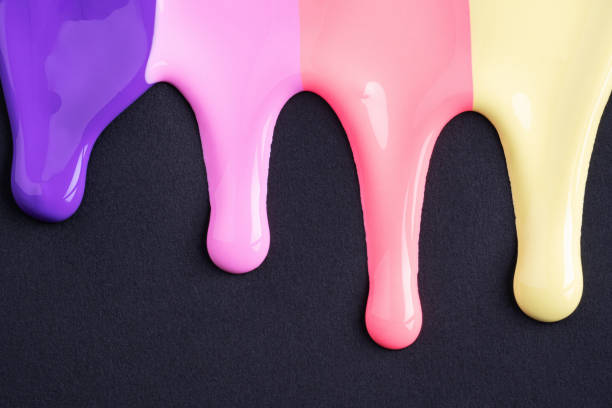 istock Rainbow liquid drops of paint color flow down on black paper. Abstract art. Multicolored paint dripping on the black wall 1482766689